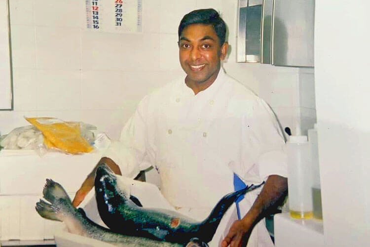 Young chef Hemi carrying two whole fish